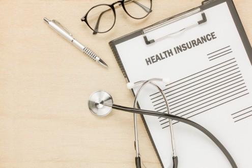 Health insurance form with stethoscope and glasses