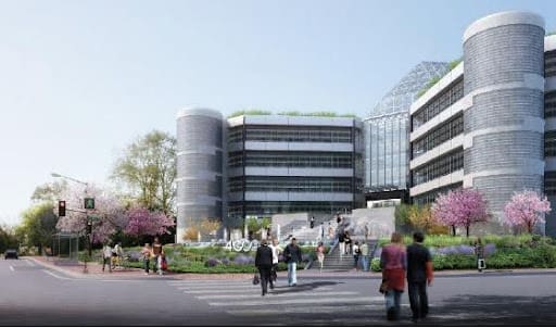 Modern office buildings with people walking in a landscaped urban area.