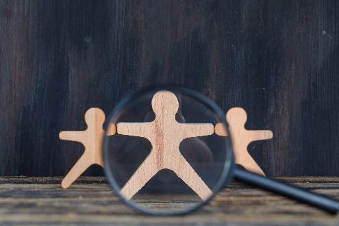 wooden paper-figure chain with magnifying glass