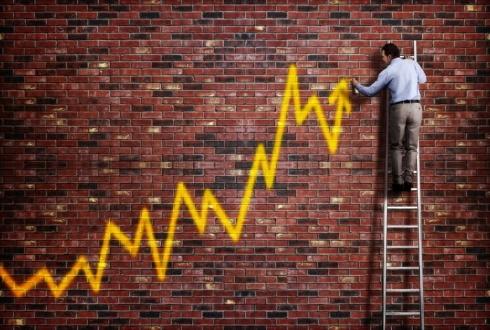Man on ladder drawing ascending yellow chart