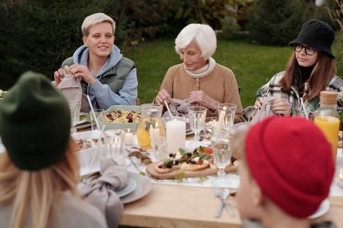 Outdoor family gathering around a candlelit dinner table