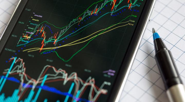 Smartphone showing stock charts with pen