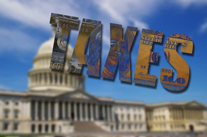 Capitol building behind 'TAXES' text filled with money