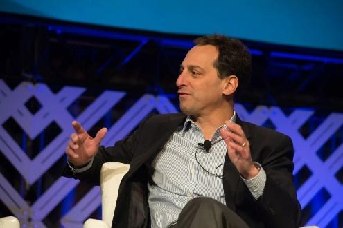 Man in suit gesturing during panel discussion