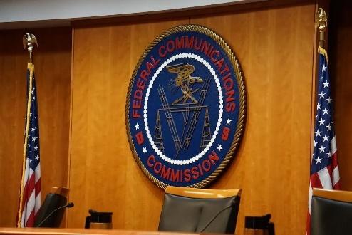Federal Communications Commission seal between American flags