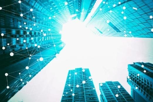 City skyscrapers with a bright digital network overlay.
