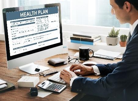 Businessman reviewing health plan on desktop