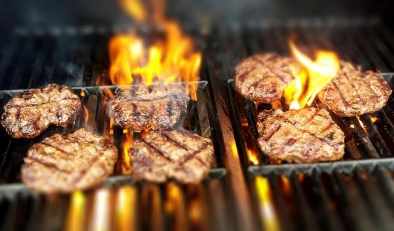 Grilled burgers cooking over open flame