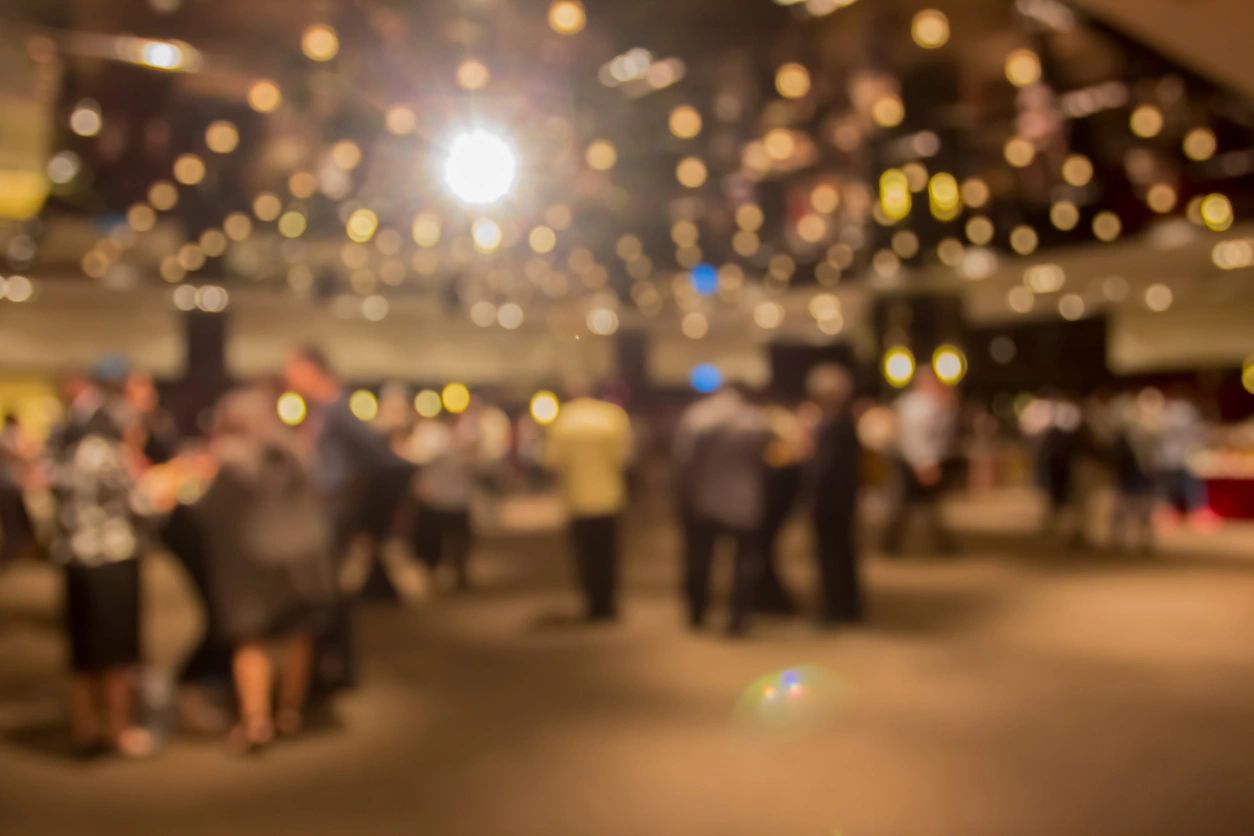 Blurred crowd at indoor party with bokeh lights