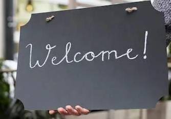 A blackboard sign with 'Welcome!' written in white chalk.
