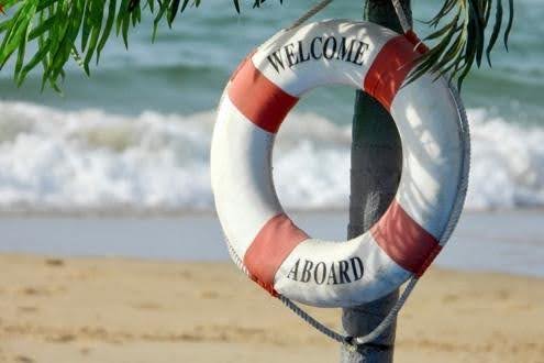 Lifebuoy reading 'Welcome Aboard' on beach