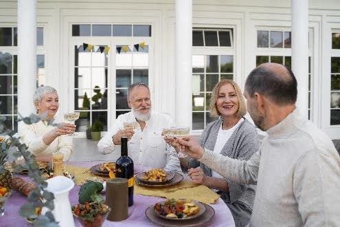 Friends toasting at outdoor dining table
