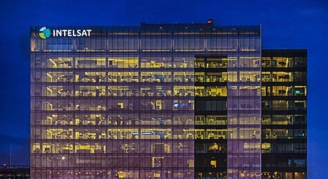 Exterior view of a large office building illuminated at night.