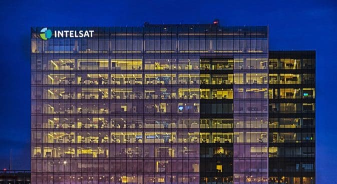 Illuminated office building at night with workers inside.