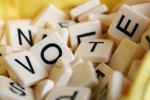 Scrabble tiles spelling "VOTE" and others.