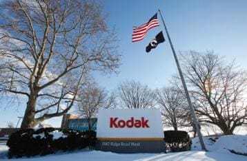 Kodak headquarters sign with American and POW flags flying.