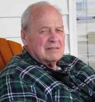 Older gentleman wearing green plaid jacket on porch