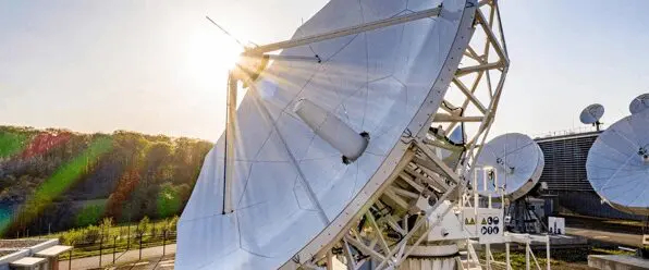 satellite dish array receiving signals at sunset