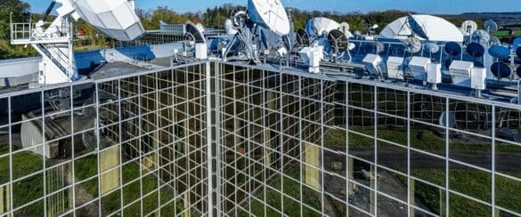 Large satellite dishes mounted on a tall communication tower.