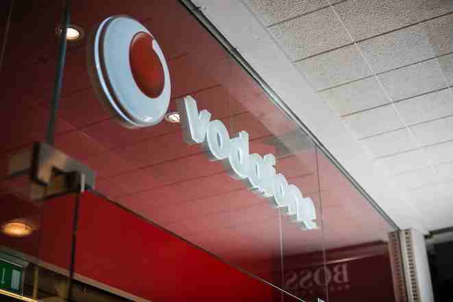 Vodafone store sign on a red wall.