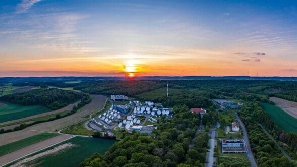 Sunset over a lakeside residential community surrounded by greenery.