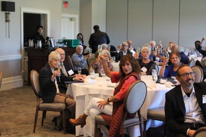 Group of people seated around a table at a formal event.