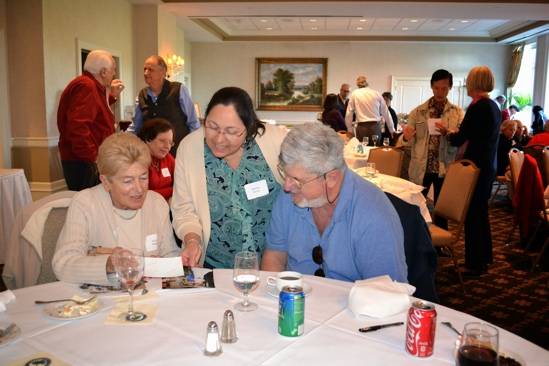 A group of elderly people enjoying a meal and conversation together.