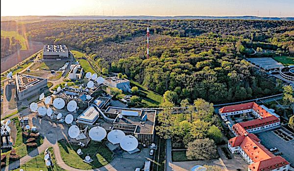 Aerial view of a satellite communication station near a forest.