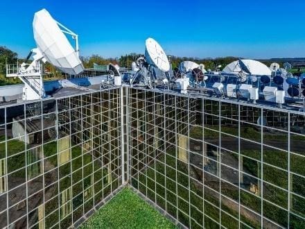 Array of parabolic dishes on reflective rooftop