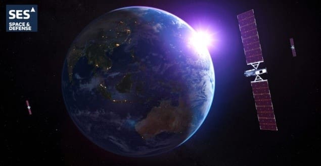 Satellite with solar panels orbiting Earth at sunrise
