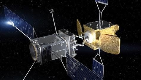 Two spacecraft docking in space against a starry background.