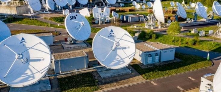 Satellite dishes at a communication facility on a sunny day.