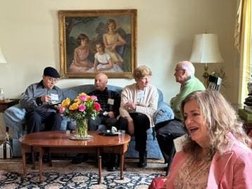 A group of friends joyfully gathered in a cozy living room.