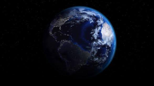 Earth viewed from space showing night lights on the dark side.