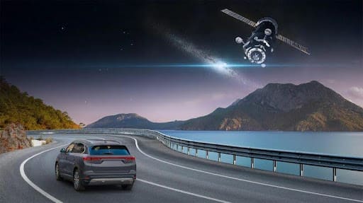 Car driving on a bridge at night with a satellite overhead.