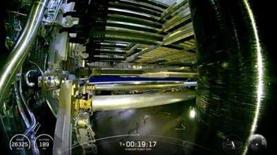 Interior view of a large rocket engine test facility with complex piping.