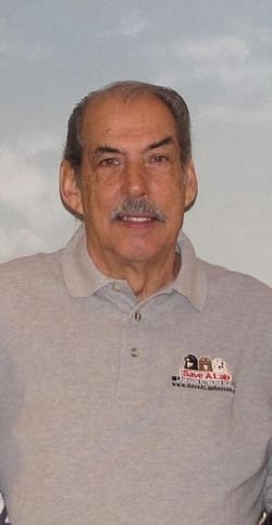 Man in gray polo shirt smiling.