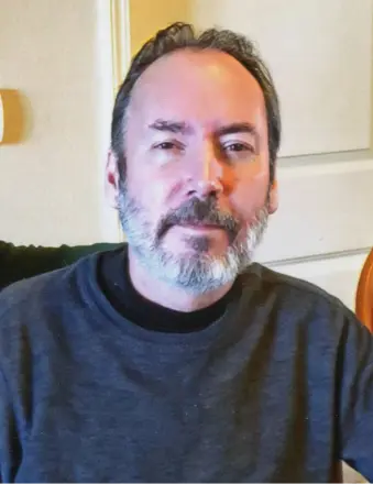 Man with beard in a gray shirt.