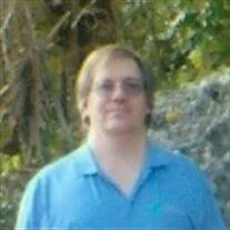 Man in blue shirt standing outdoors.