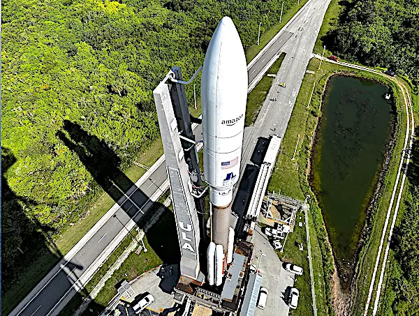 Rocket on launch pad with surrounding greenery.