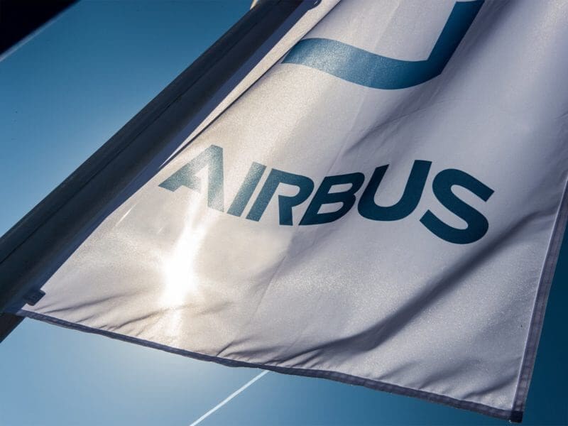 Airbus flag waving under blue sky.
