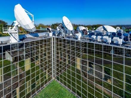 Satellite dishes on a building rooftop.