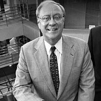 Man in suit smiling in an office.