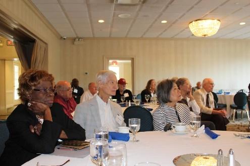 Elderly people attending a formal gathering.
