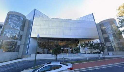 Modern building with glass facade and car.