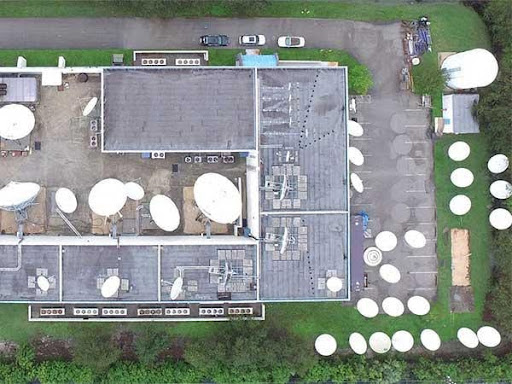Aerial view of building with satellite dishes.