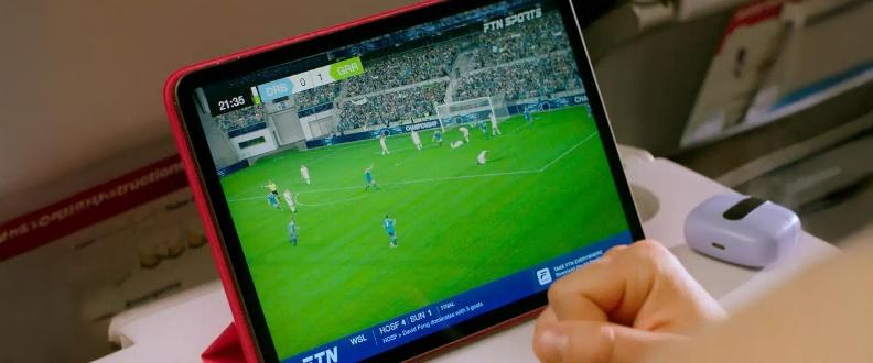 Watching soccer match on tablet during flight.