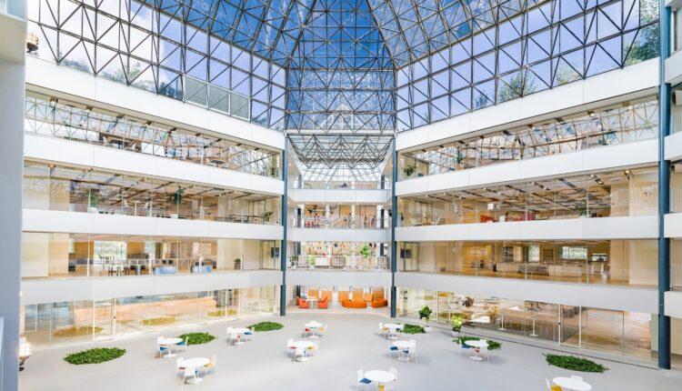 Modern atrium with glass ceiling and seating.