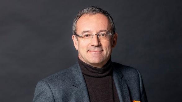 Man in glasses wearing a gray suit.
