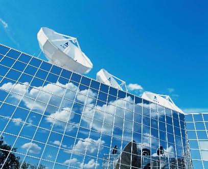 Reflective building with satellite dishes and sky.